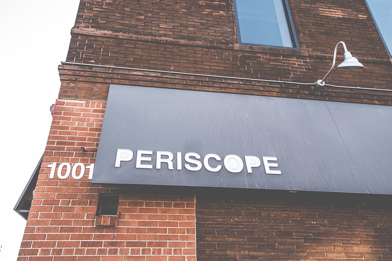 Backsteinfassade mit Schild 'PERISCOPE' und Hausnummer 1001