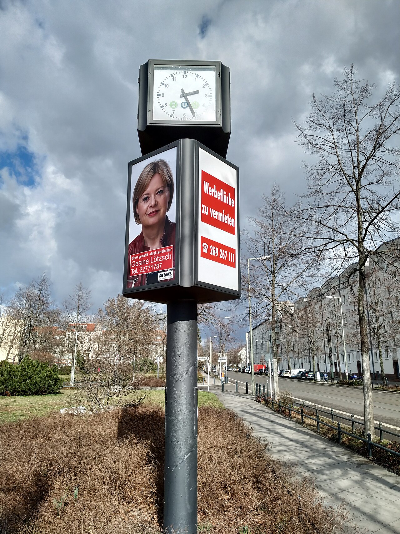 Werbesäule mit Uhr und Werbeplakaten in Berlin-Alt-Hohenschönhausen