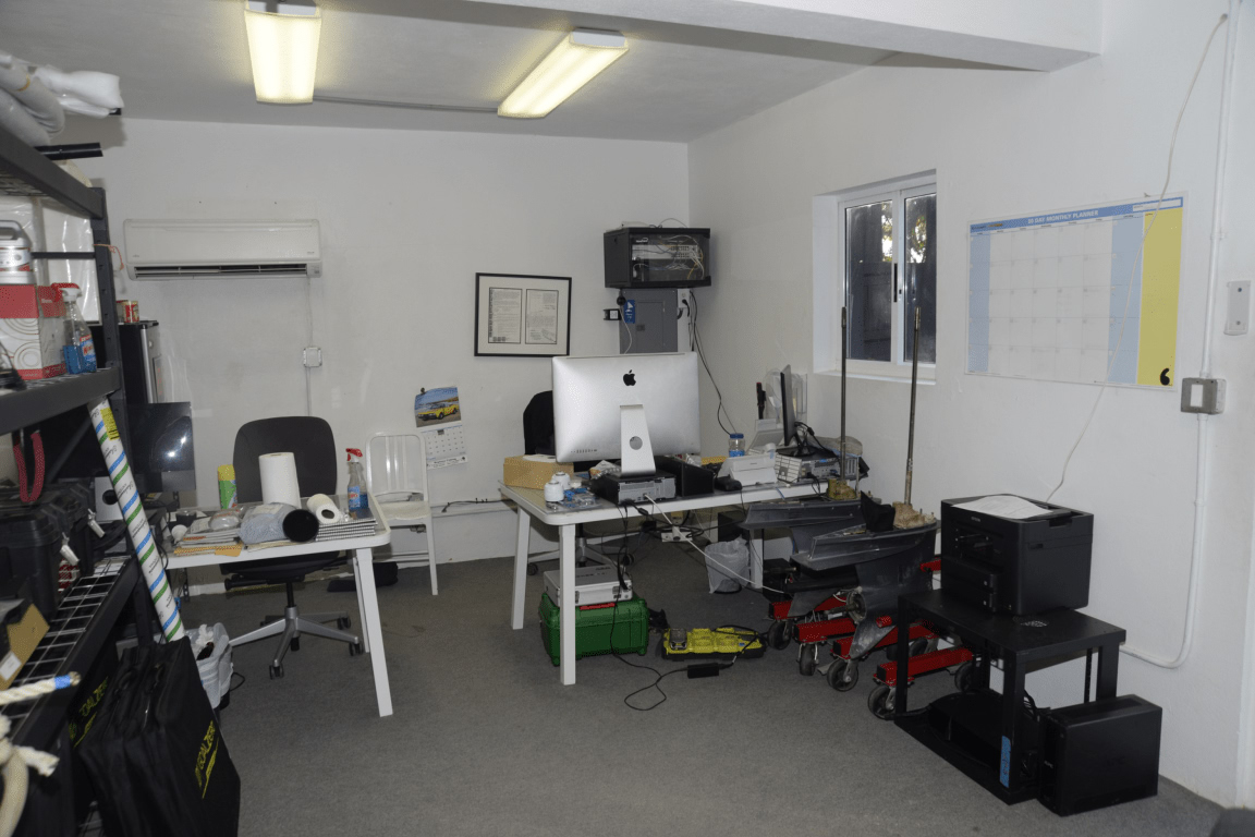Büro mit Schreibtischen, Computern, Drucker und Wandplaner