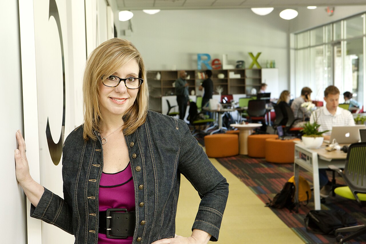 Frau in Coworking-Büro mit Personen an Laptops