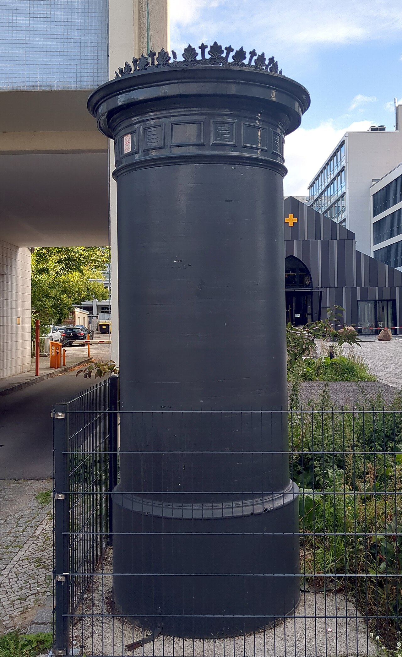 Litfaßsäule hinter einem Metallgitterzaun in Berlin-Wedding
