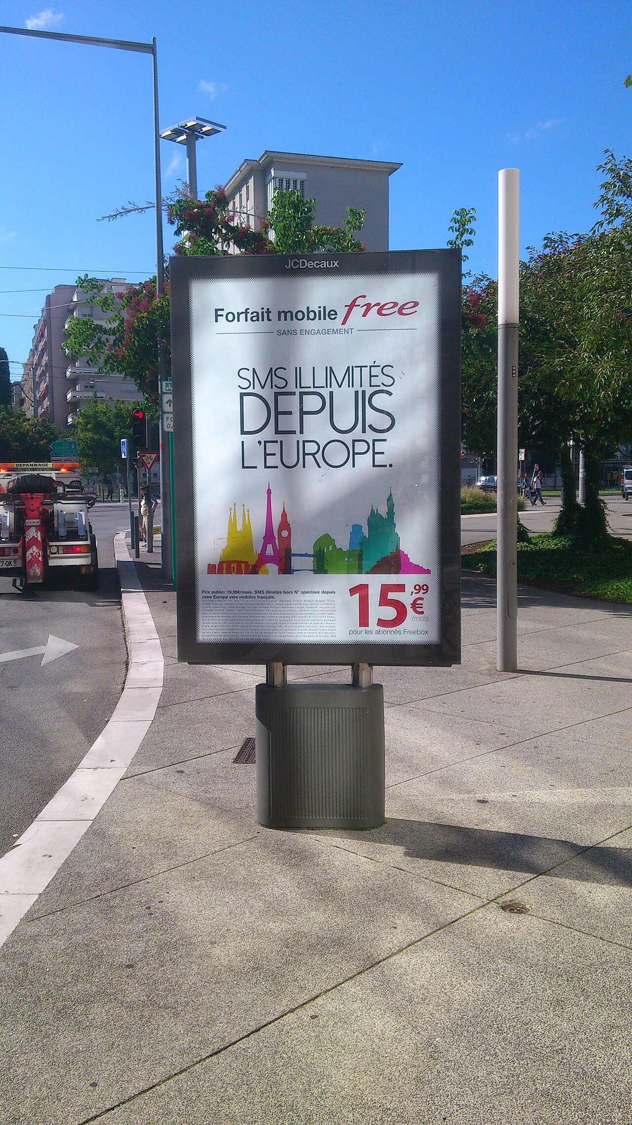Beleuchteter Werbeträger mit Mobilfunk-Plakat an einer Straße