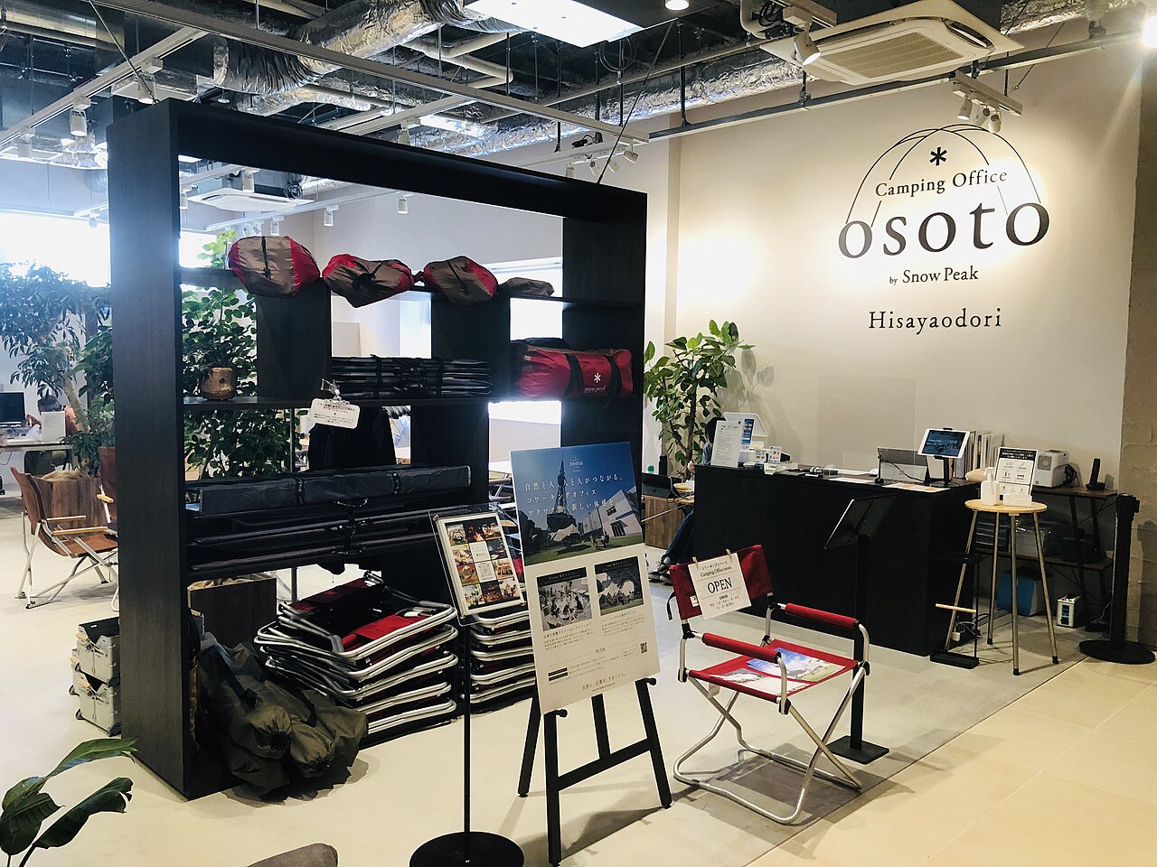 Innenraum eines Coworking-Space mit Outdoor-Ausrüstung, Tresen und Markenbeschriftung