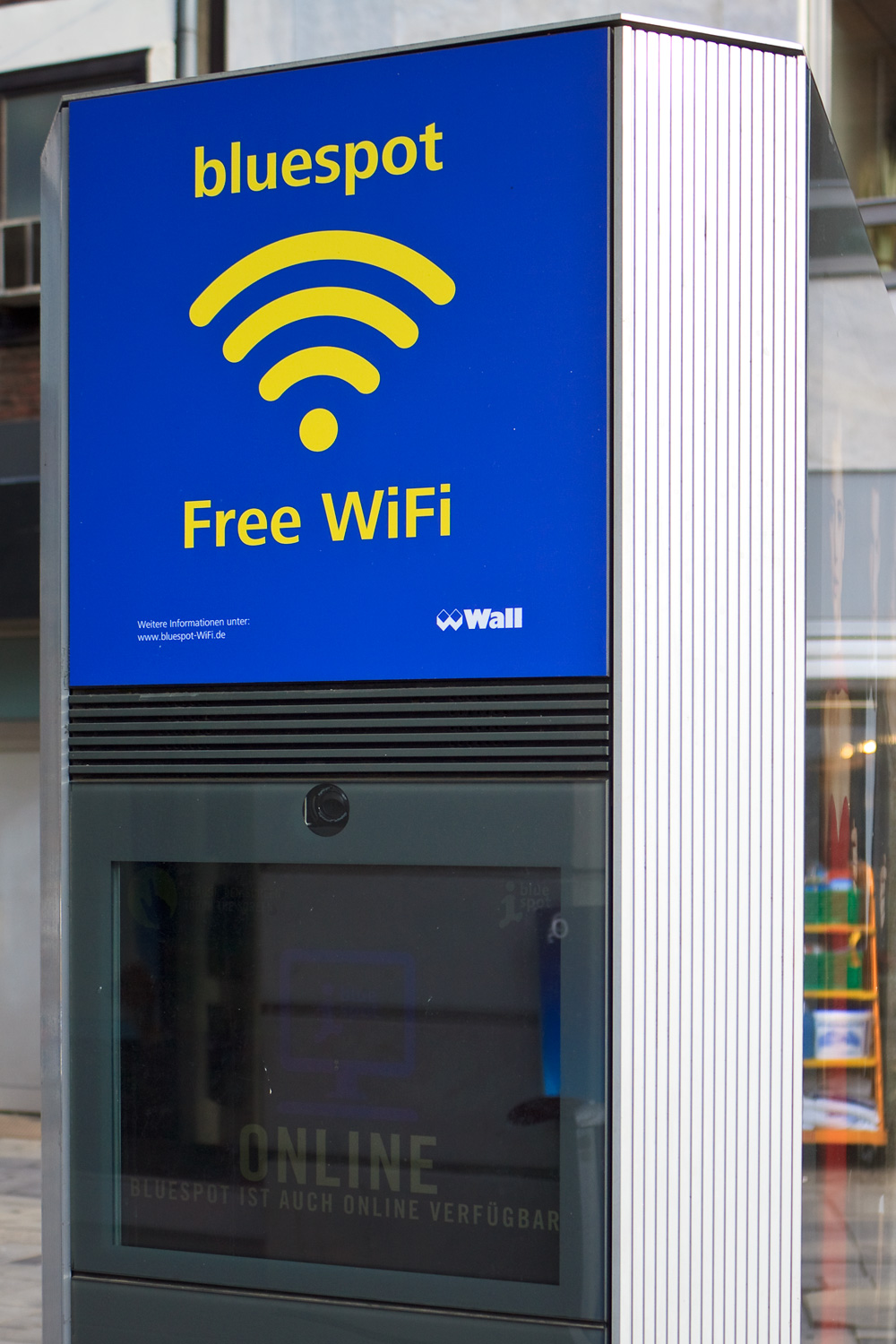 Blauer Werbekasten mit WLAN-Symbol und Aufschrift bluespot Free WiFi