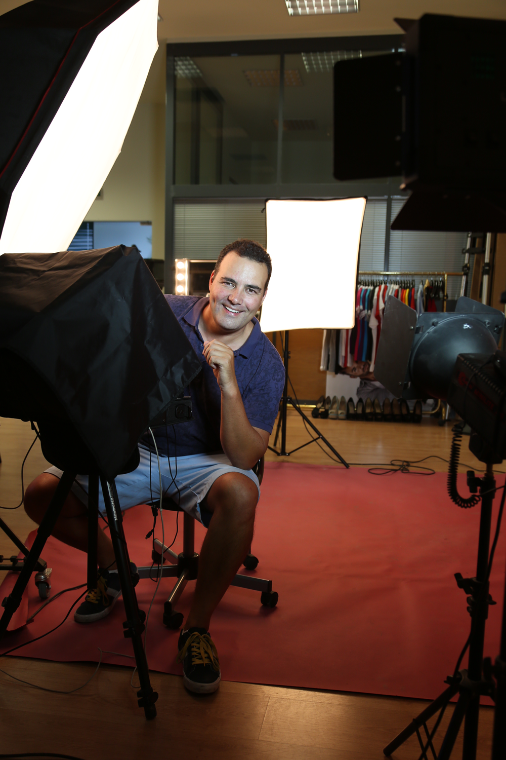 Mann in einem Fotostudio mit Beleuchtung und Kleiderstange