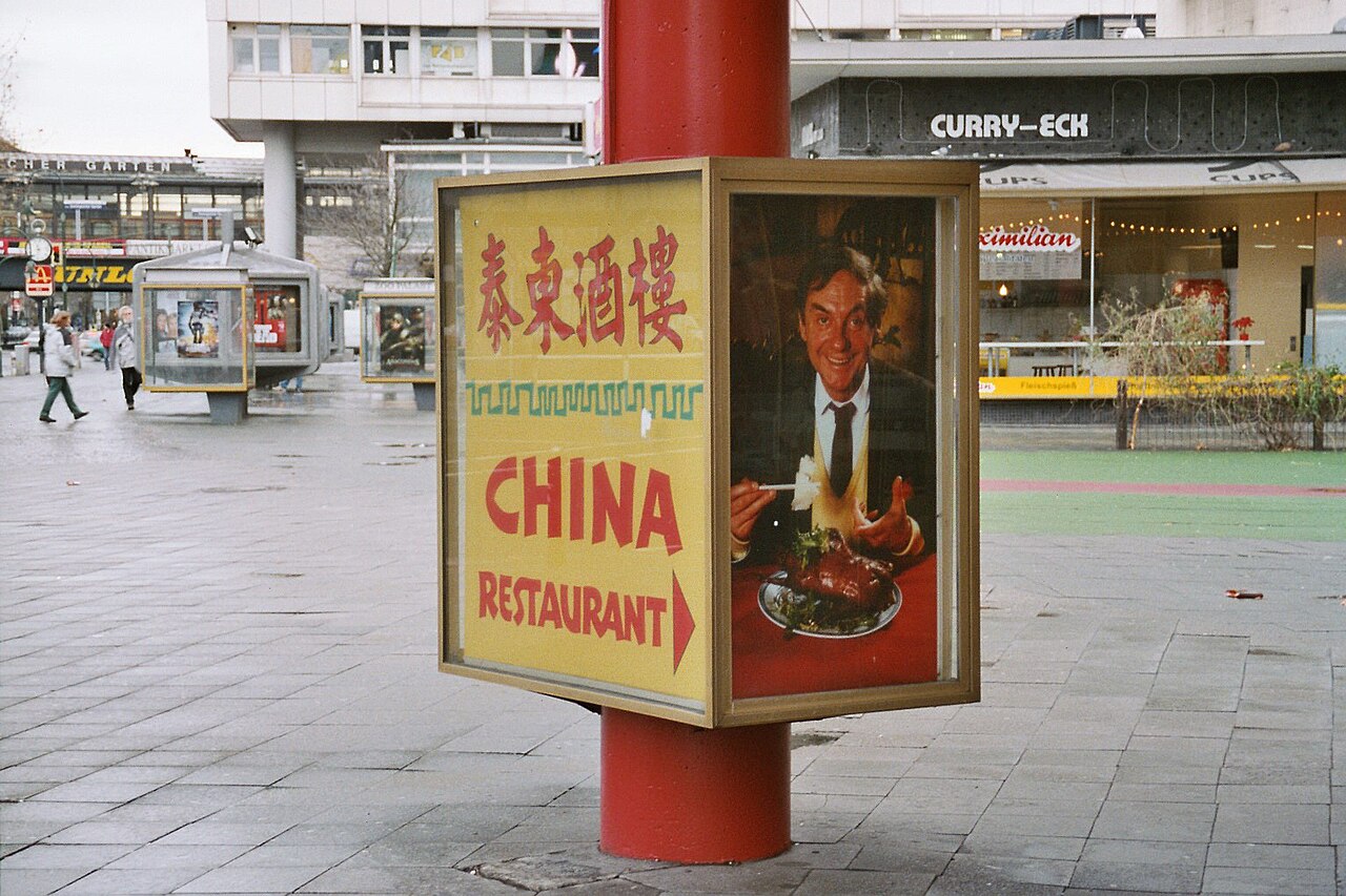 Werbeaufsteller mit Leuchtkasten für ein China-Restaurant auf einem gepflasterten Platz